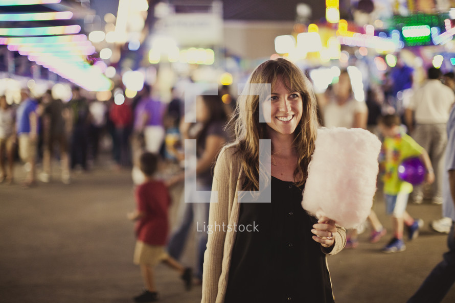 woman holding cotton candy at a fair