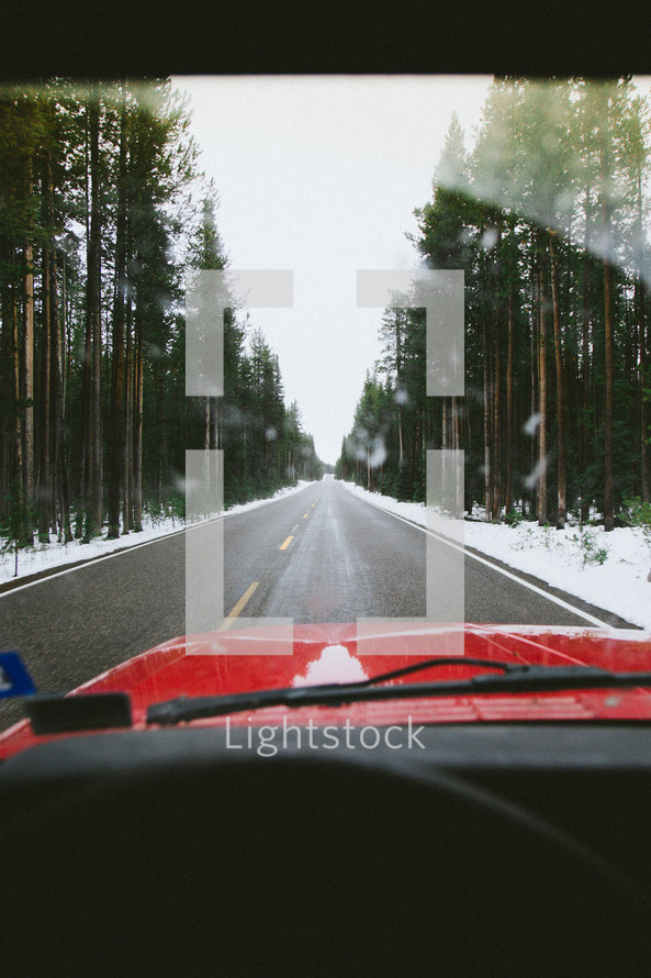 red SUV traveling through snow 
