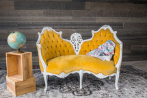 yellow vintage couch and globe on wood crates 
