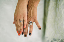 A bride and her mother's hands wearing their wedding rings.