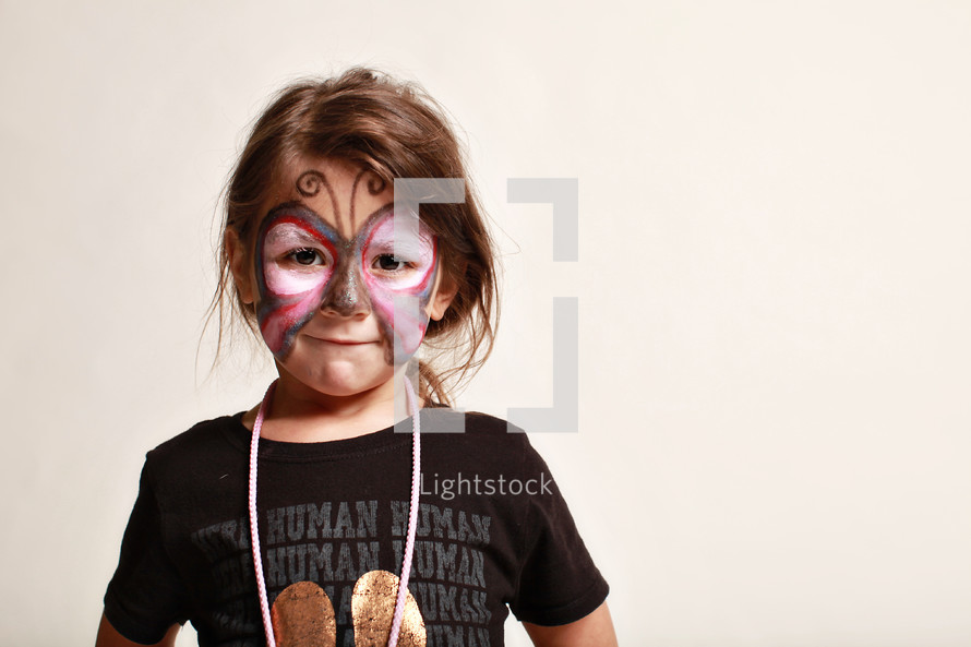 little girl with her face painted as a butterfly