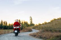 Santa riding away on a dirt bike 
