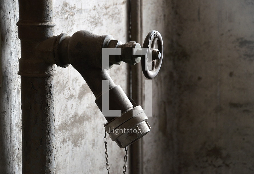 Pipe faucet and handle on a brick wall.