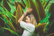 a woman standing amongst tropical plants 