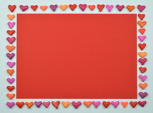 frame out of clay hearts on white with red paper in the middle and copy space above as sign for love and relationship