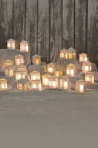 Advent calendar out of 24 self small made white round paper houses illuminated from the inside on white satin for Advent with copy space below