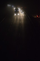 View from a bridge at a highway by night on a cold foggy winter night. 
