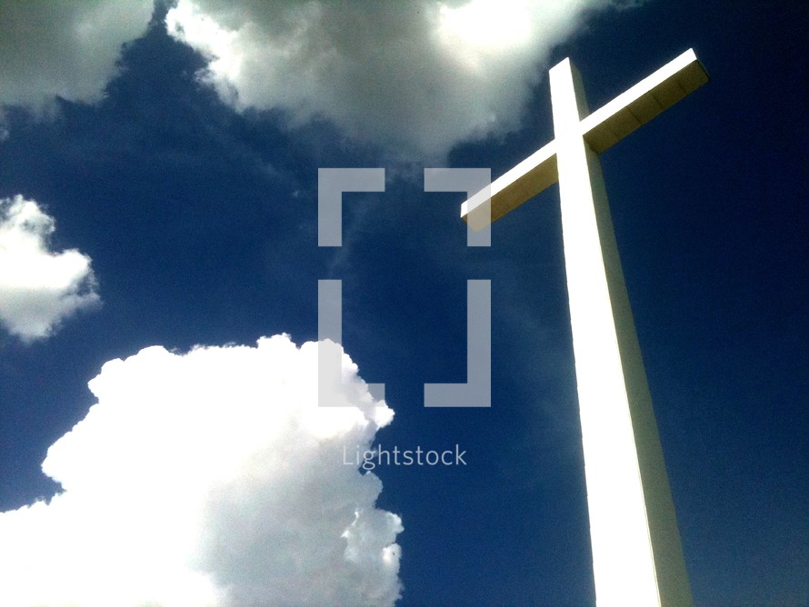 the reach of the cross that reaches from heaven to earth against a blue sky and clouds. What an amazing view and reminder of Gods love that He came down from Heaven to Earth to minister to each of us and win us back one at a time to a restored relationship with Christ and God the Father. 