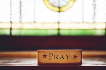 pray sign and stained glass window 