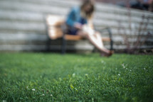 blurry image of a woman sitting on a park bench 