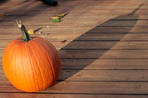 orange pumpkin on a wood deck 