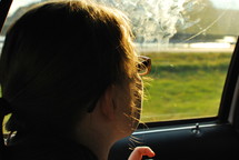 a woman looking out a car window 