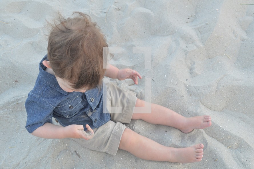 toddler boy playing in sand 
