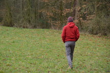 a man walking over a meadow