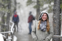 woman standing outdoors in falling snow 