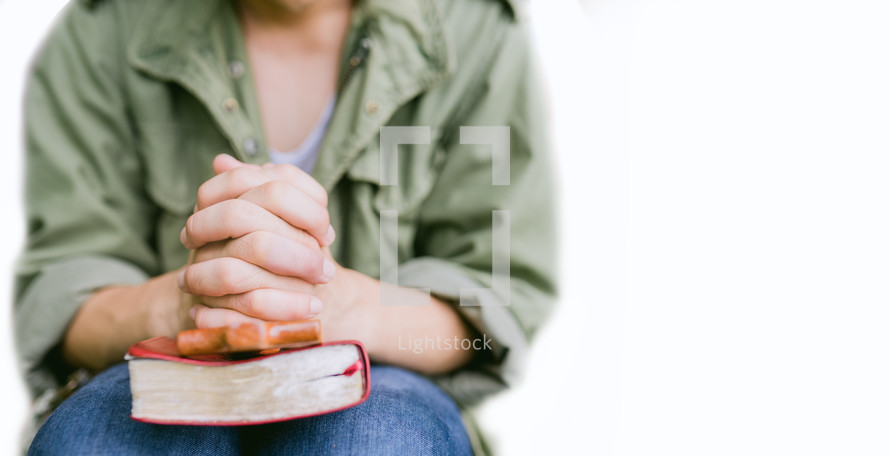 teenage boy hand with Bible praying