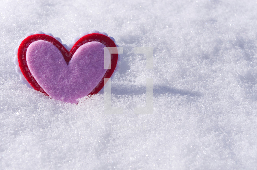 red and pink heart in snow 
