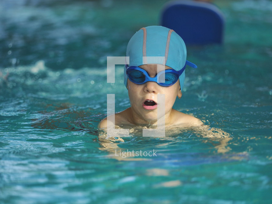  boy swimming in an indoor pool