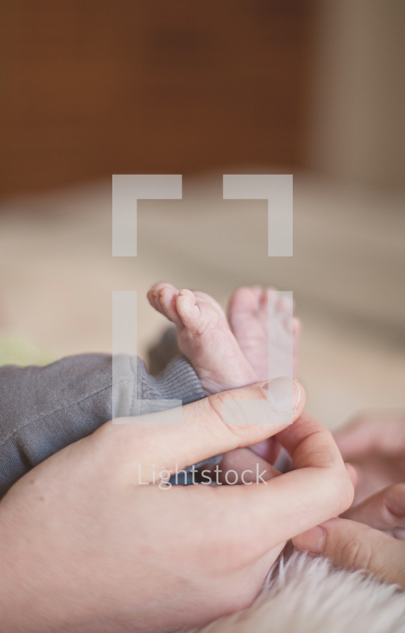 father holding his son's tiny newborn feet