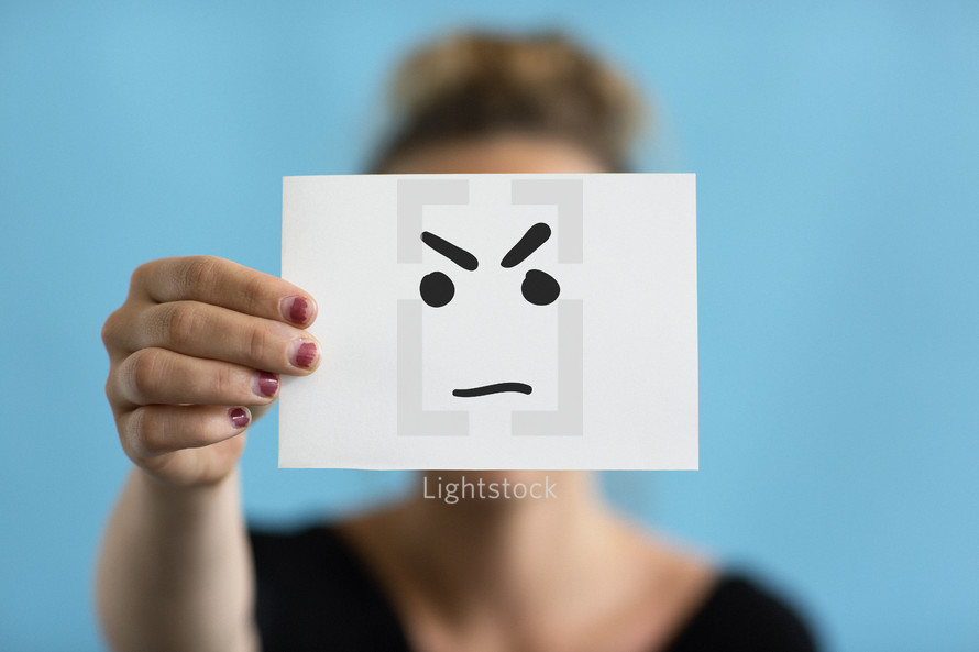 a woman holding up an angry face