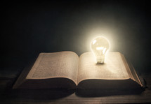 open Bible with lightbulb 