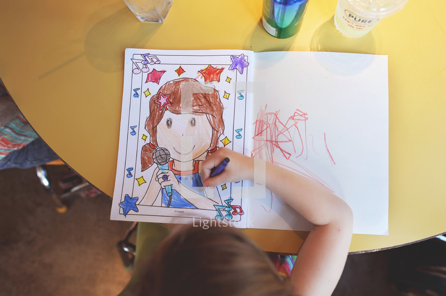 a child coloring in a coloring book 