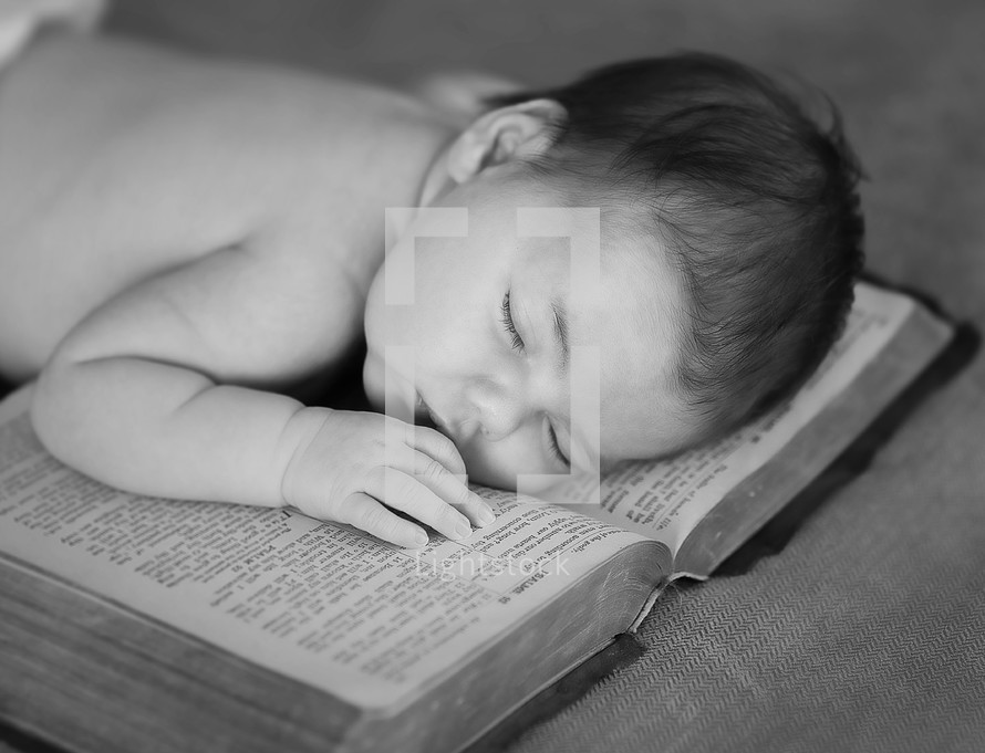 an infant sleeping on a Bible