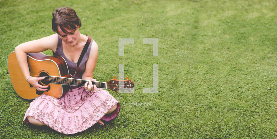 a woman playing a guitar 