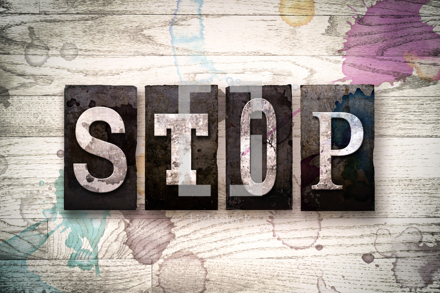 word stop on a white wash wood background 