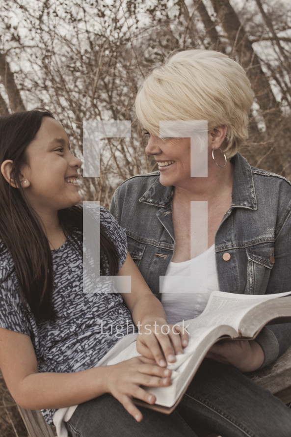 woman and a girl reading a Bible together - mentoring 