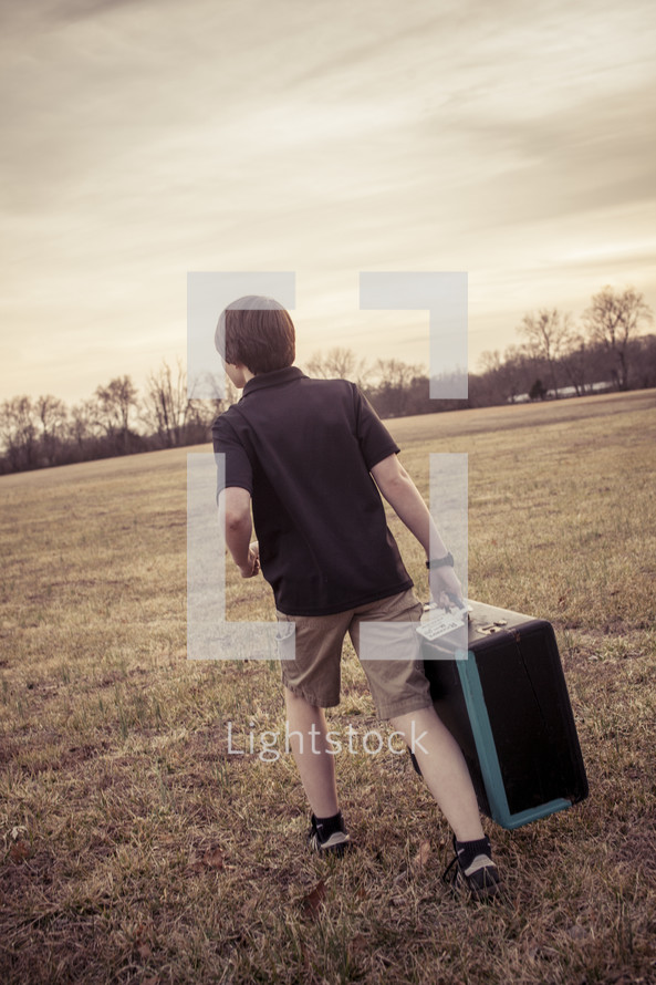 teen boy carrying an instrument case 