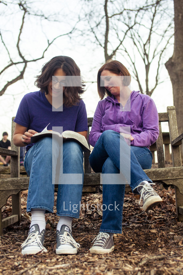A young man and a woman reading a Bible - mentoring 
