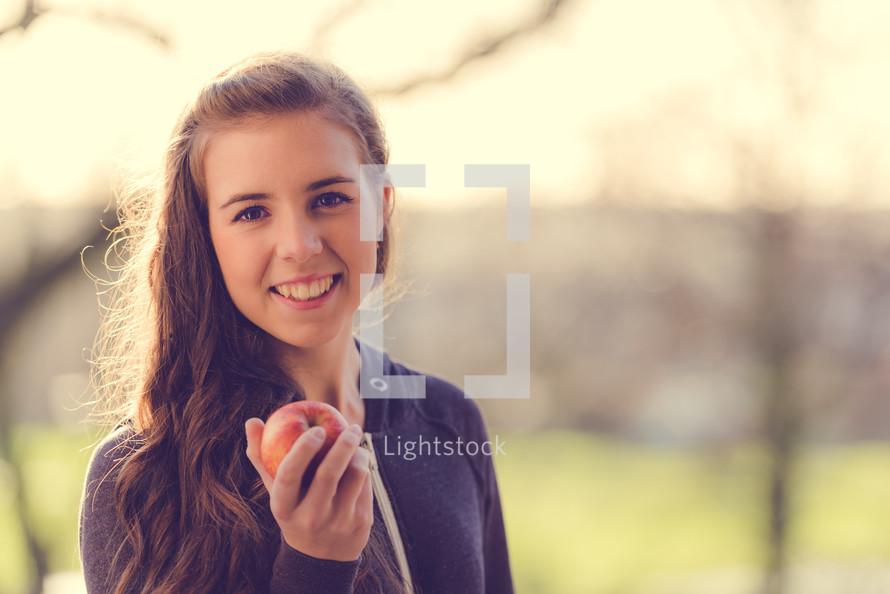teen girl holding an apple 
