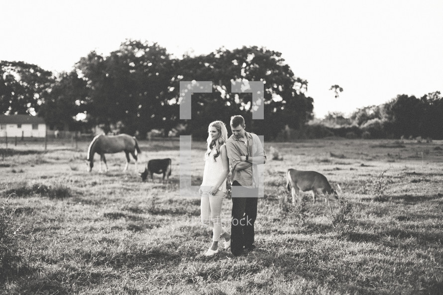 a couple standing on a farm 