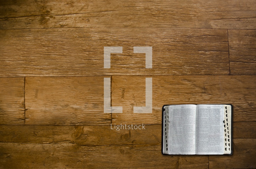 open bible on a wood floor 