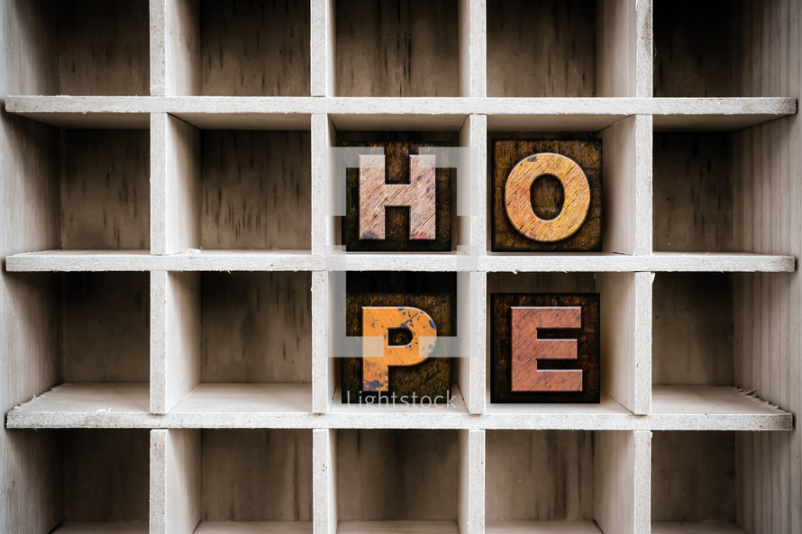 Wooden letters spelling "hope" on a wooden shelf.