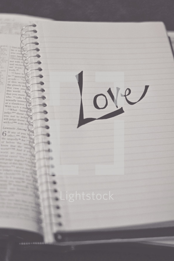 love on a notebook on the pages of a Bible 