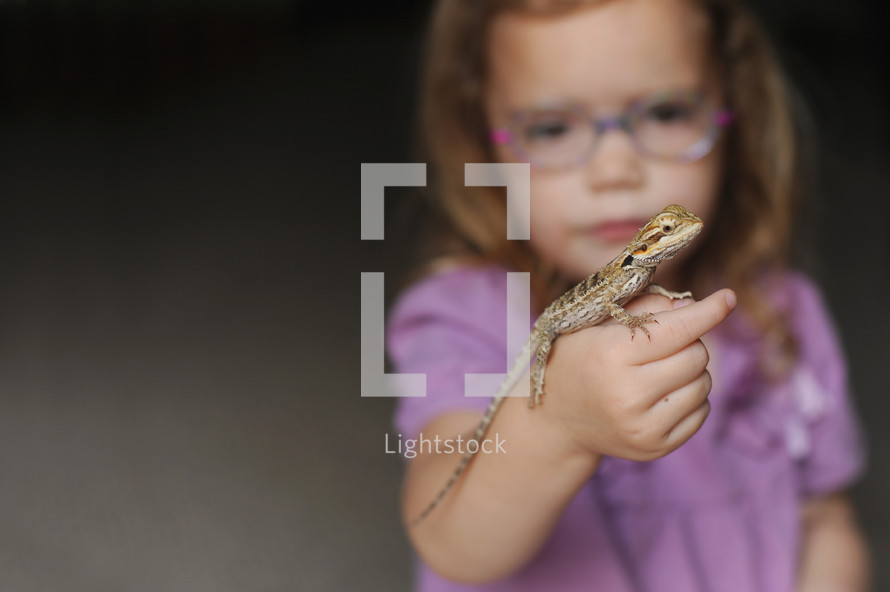 a girl holding a lizard 