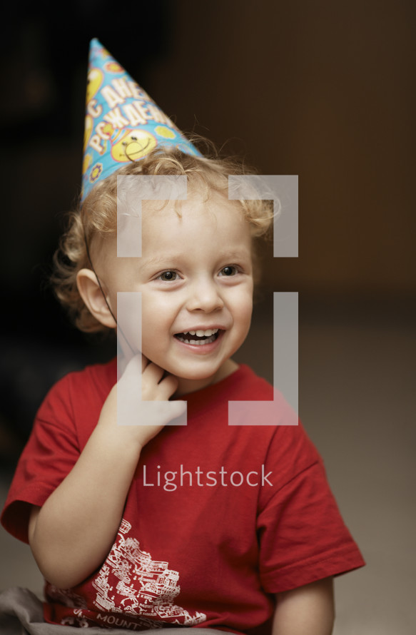 Cute happy young boy in a party hat