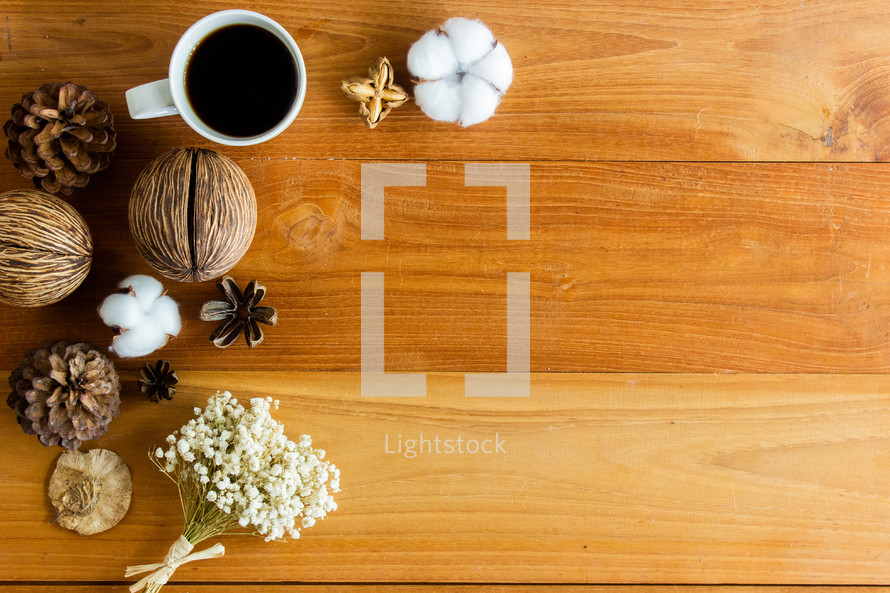 coffee cup and pine cones on a wood desk 