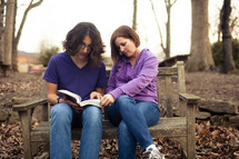 woman reading a Bible with a young man - mentoring 