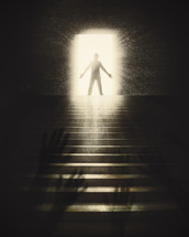 raised hands and a silhouette of a man standing in a doorway in sunlight 