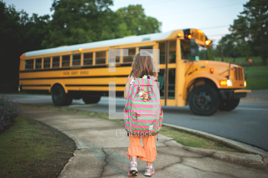 a child waiting at the bus stop 
