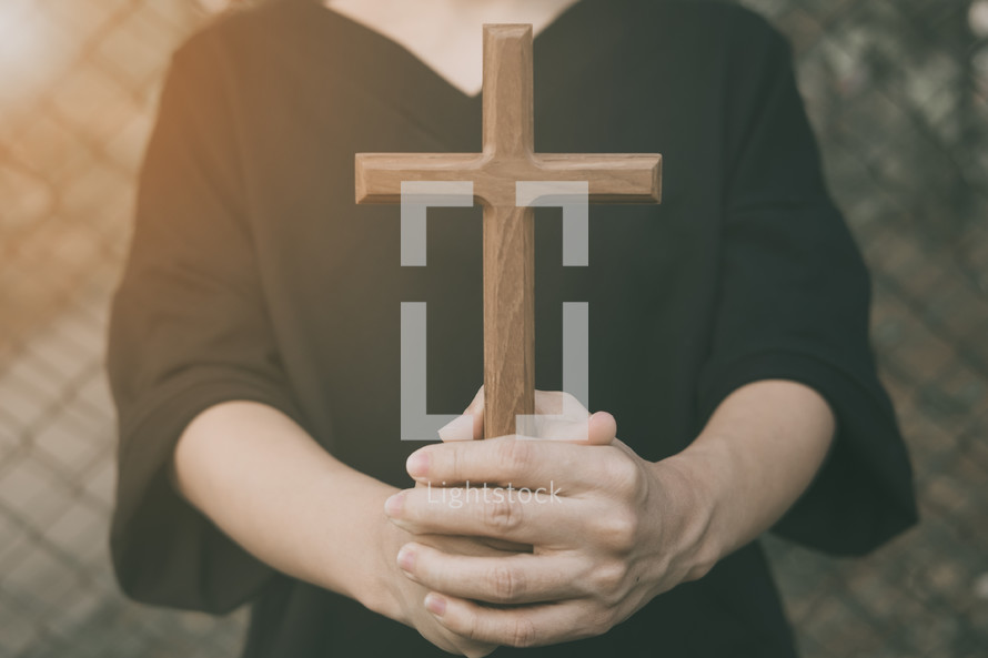 a woman holding a wooden cross