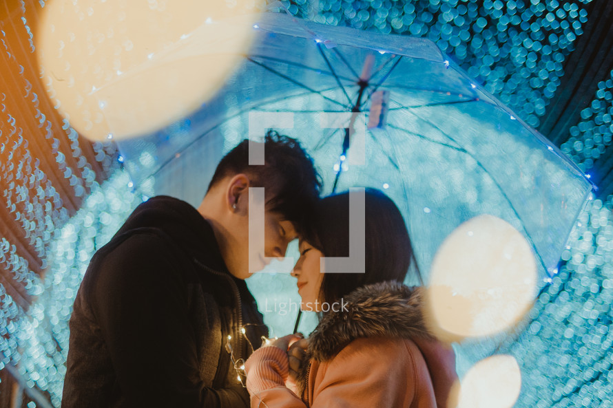 a couple in love standing under an umbrella 