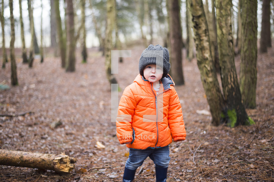a child in a coat in a forest 