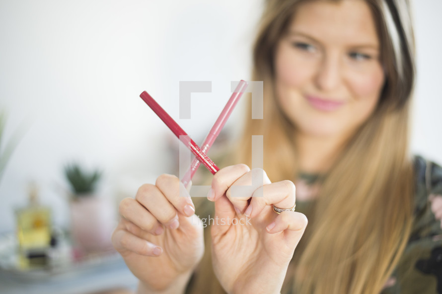a woman making an X with pencils 