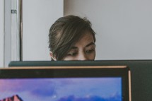 a woman behind a computer screen