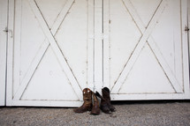 Mens and Women's boots by a barn