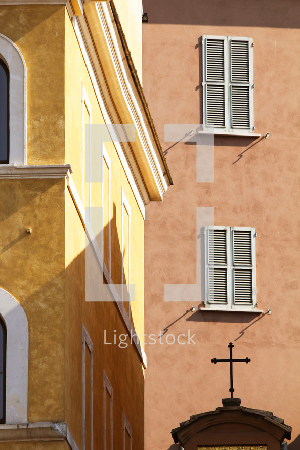 buildings in  Italy and cross on an arched church door 